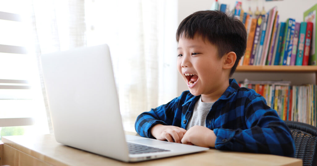 Boy using laptop for homework at home